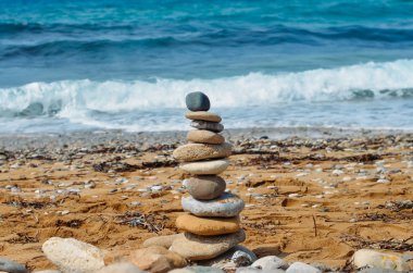 Çakıl taşları kum plaj ve deniz arka plan üzerine gelen piramit. Hol