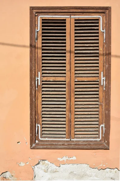 Vieille fenêtre en bois brun avec volets et mur avec douleur fissurée — Photo