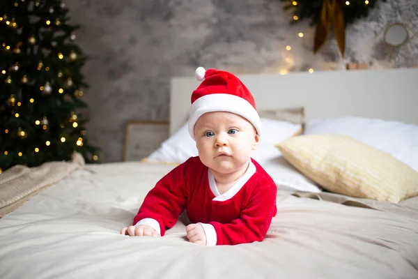 Adorable enfant au lit, portant un bonnet de Noël rouge — Photo