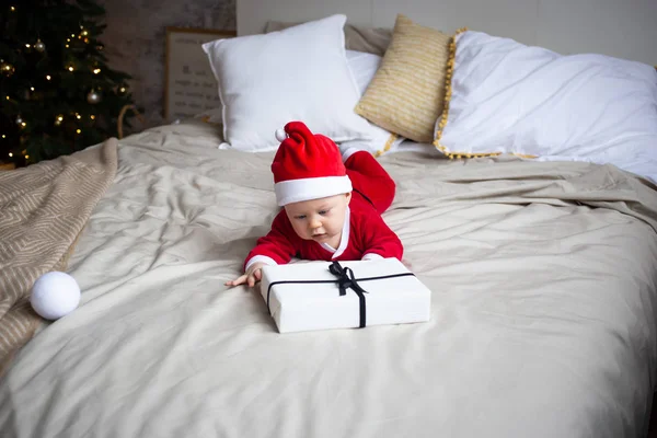 Petit garçon avec des boîtes-cadeaux sur le lit à la maison — Photo