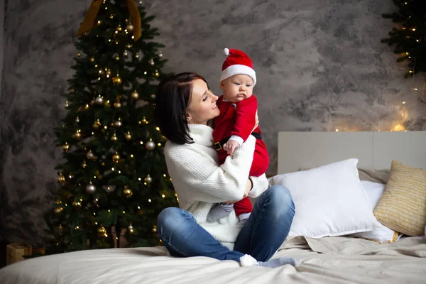 Jovem mãe feliz com bebê em chapéu de Santa — Fotografia de Stock