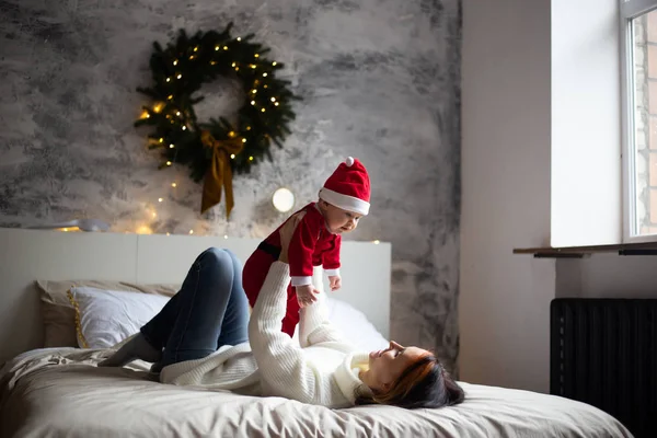 Glad familj mamma och lille son leker hemma på julhelgen. Nyårssemester. — Stockfoto