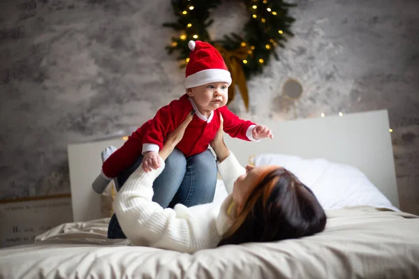 Mère et petit bébé dans des chapeaux de père Noël à la maison — Photo