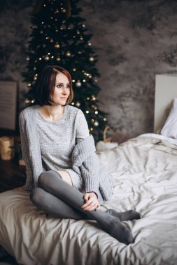 Genç bir kadın Noel 'de yatağında dinleniyor.