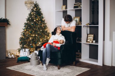 aile, anne, baba ve bebek evdeki bir Noel ağacının yanında