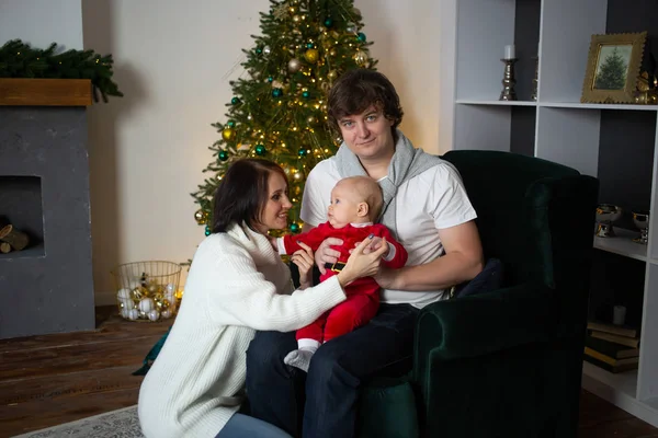 Familia feliz con el bebé cerca del árbol de Navidad en casa — Foto de Stock