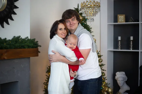 クリスマスの冬休みに家で抱きつく若い家族 — ストック写真
