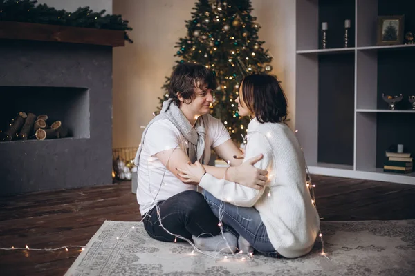 Doce amor jovem casal abraçando sobre árvore de Natal — Fotografia de Stock