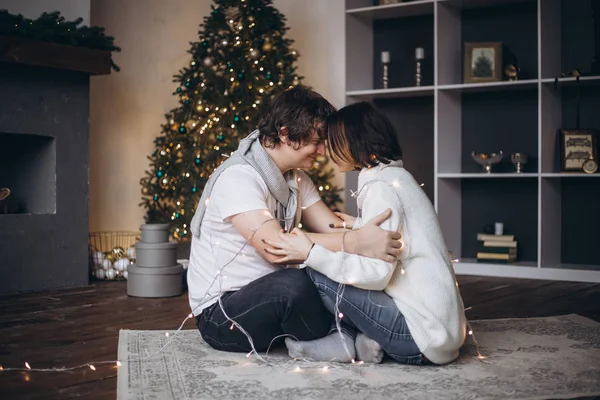 Imagem de um jovem casal abraçando na época do Natal — Fotografia de Stock