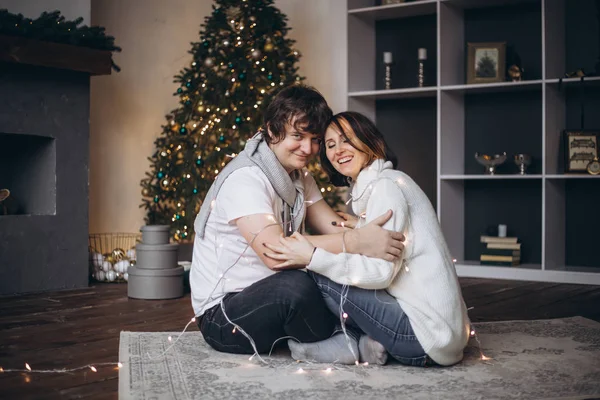 Улыбающаяся пара обнимается в Рождество дома — стоковое фото
