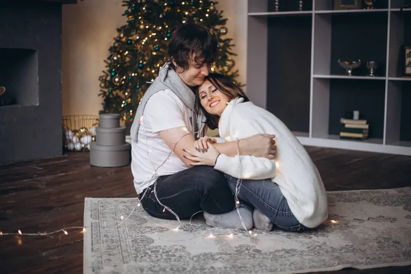 Par i kärlek kramas i juletid hemma — Stockfoto