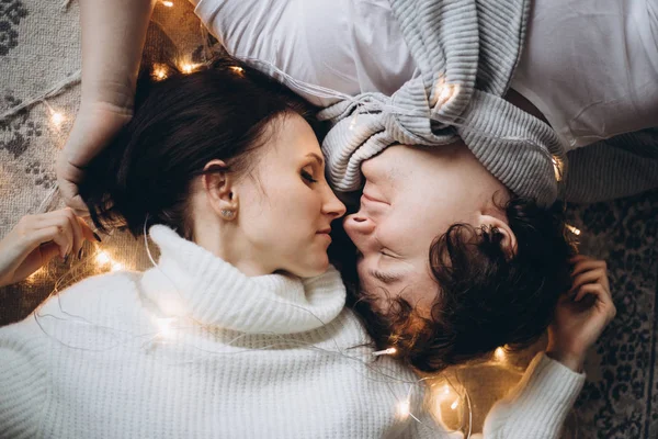 Casal apaixonado beijando na véspera de Natal perto da árvore com presentes em casa em dezembro . — Fotografia de Stock