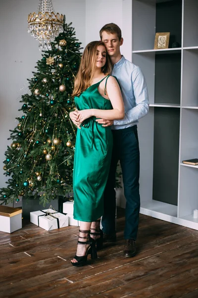 Pareja elegante que se encuentra cerca del árbol de Navidad, Año Nuevo — Foto de Stock