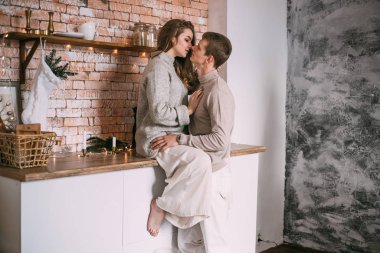 Genç ve neşeli bir çift mutfakta kahvaltı yaparken eğleniyor..