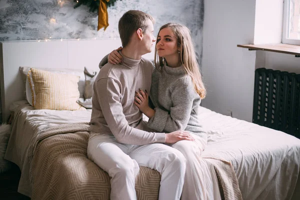 Casal olhando uns para os outros perto da janela em sua cama na hora do Natal — Fotografia de Stock