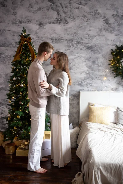 Романтична пара біля ліжка розслабляється вдома в різдвяний час, різдвяна концепція — стокове фото