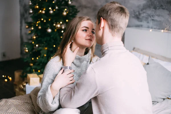 Casal na cama celebrando Ano Novo e Natal perto da árvore de Natal — Fotografia de Stock