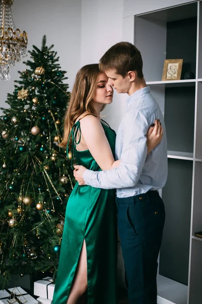 Älskade par kramas nära julgranen — Stockfoto
