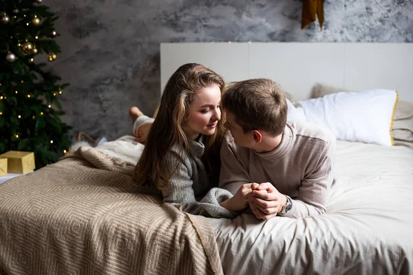 Unga kärleksfulla par kyssas i sängen hemma — Stockfoto