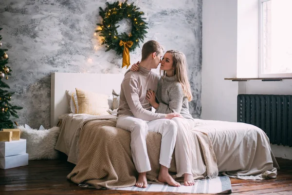 Unga lyckliga par i säng vid jul — Stockfoto