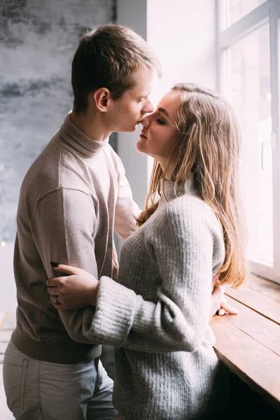 Casal beijando perto de janela em casa — Fotografia de Stock