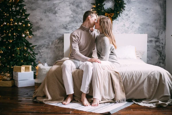 Пара цілується на своєму ліжку в різдвяний час — стокове фото