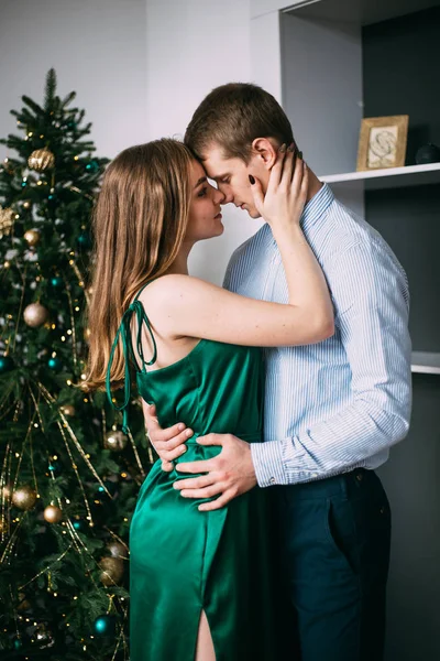 Unga snygga par kramas över julgran, nyår — Stockfoto