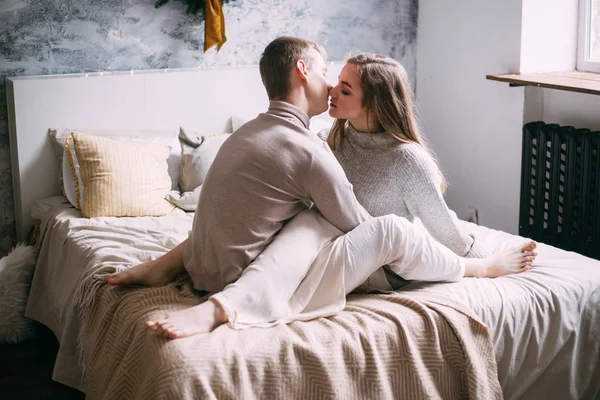 Casal beijando em seu quarto perto da janela — Fotografia de Stock