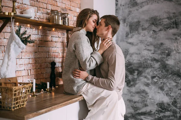 Bonito jovem casal abraçando na cozinha em casa — Fotografia de Stock