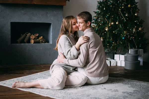 Пара вдома в різдвяний час біля красиво прикрашеної ялинки — стокове фото