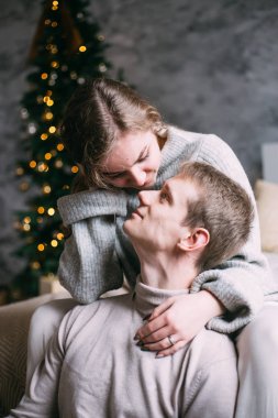 Genç çift Noel zamanı evde öpüşüyor.