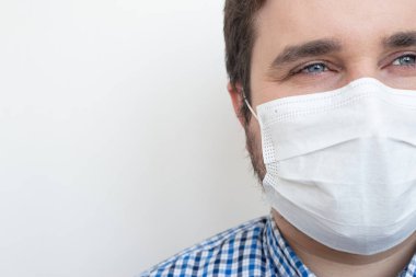 Mikropları, zehirli dumanları ve toz bulutlarını önlemek için maske takan bir adam beyaz arka planda, kopyalanmış mekanda, kopyalanmış yerde, mesajlaşmak için izole edilmiş. Bakteriyel enfeksiyonun önlenmesi Coronavirüs