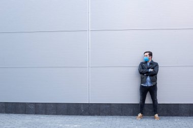 Sokaktaki koruyucu maskeli adam. Grip olmuş, maske takan, salgın hastalık salgını, koronavirüs, hastalık, enfeksiyon, karantina, tıbbi maske takan bir adam.