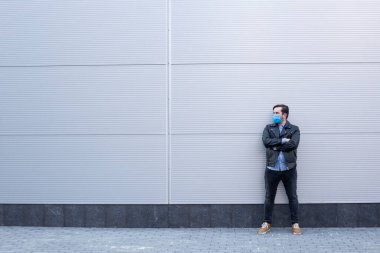 Sokakta koruyucu maske takan bir adam. Grip olmuş, maske takan hasta bir adam. Sokakta salgın hastalık konsepti..