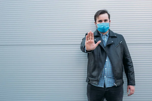 stop coronavirus. man wears protective mask against infectious diseases and flu. man showing gesture stop. health care concept.