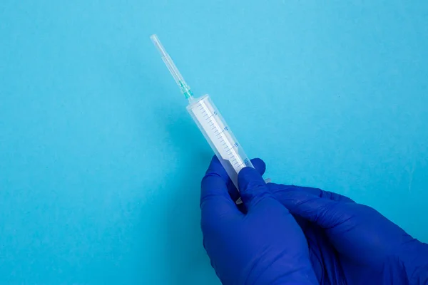 Hand Mit Spritze Isoliert Auf Blau Hand Blauen Latexhandschuhen Coronavirus — Stockfoto