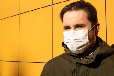 Tıbbi maske takan genç bir adamın portresi. Coronavirus konsepti. solunum koruması