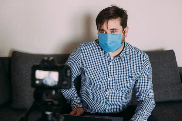 Man blogger next to video camera at home while stay home on coronavirus quarantine. Man recording vlog message at home for internet channel