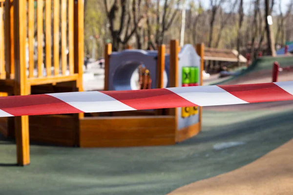 playground is closed for quarantine, playground is blocked by red warning tape, children cannot play on street because of COVID-19 closed for quarantine.