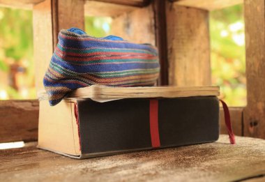 Bir c ahşap bir bankta bir çanta, bir not defteri ve eski bir kitap yalan