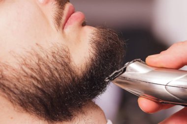 Bir tıraş makinesi bir profesyonel kuaför stilist tarafından bir kuaför dükkanında bir sakal kesme