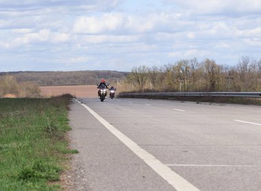 Erkek motosikletçi yüksek hızlı bir boş yolda yarış motosiklet direksiyonda. zevkle Motosiklet ile seyahat için boş bir yol geçiyor. Metin için aşırı spor, özgürlük kavramı yer