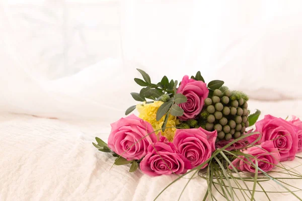 Bouquet de roses roses sur fond de lit blanc et ballons — Photo