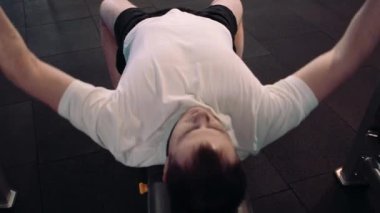 Zalim atletik adam göğüs presinde kaslarını şişiriyor.