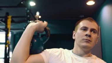 Fitness adam ağır kettlebell kaldırarak bir ağırlık çalışması yapıyor. Yong atlet kettlebell yapıyor salıncaklar. Vücut geliştirmeci kaldırma kettlebell