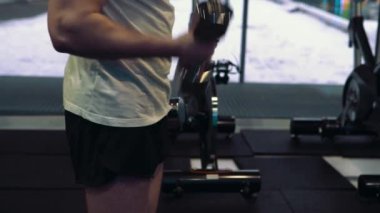 Genç bir adam, pazı dumbbells ile yapıyor. Güç ve motivasyon