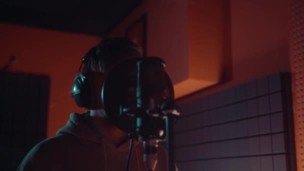 Μουσική, θεάματος, άνθρωποι και φωνή έννοια - αρσενικό τραγουδιστής με ακουστικά και μικρόφωνο τραγούδι τραγούδι στο στούντιο ηχογράφησης — Αρχείο Βίντεο