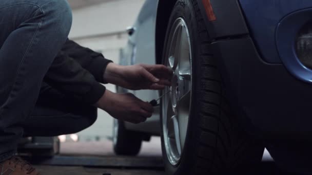 ホイールで車のワーク ショップで働くメカニック — ストック動画