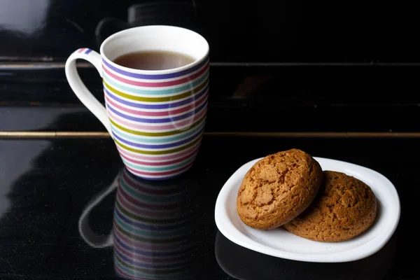 Dois biscoitos em uma chapa e xícara com chá — Fotografia de Stock