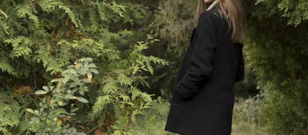 Ένα κορίτσι σε ένα μαύρο παλτό και ένα μπεζ πουλόβερ ξεχωρίζει για το backgro — Φωτογραφία Αρχείου